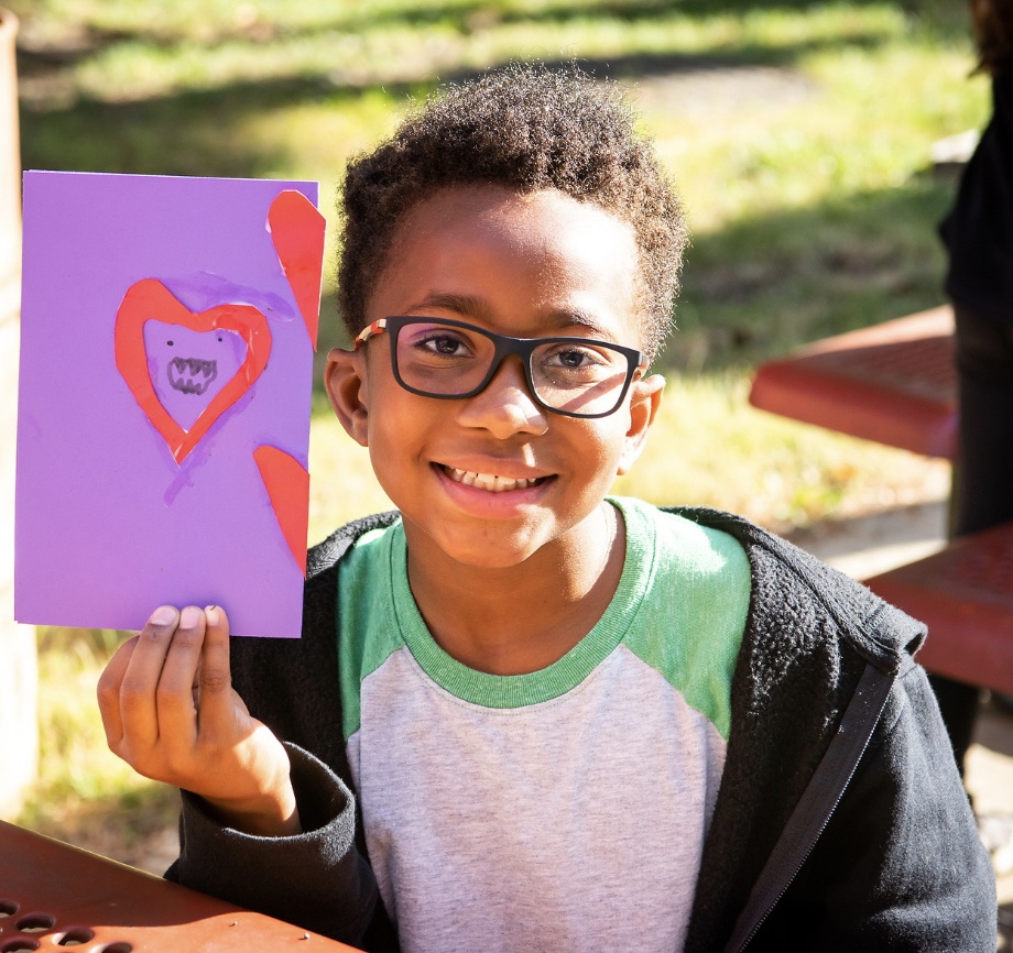 Portrait of boy smiling holding a homemade greeting card
