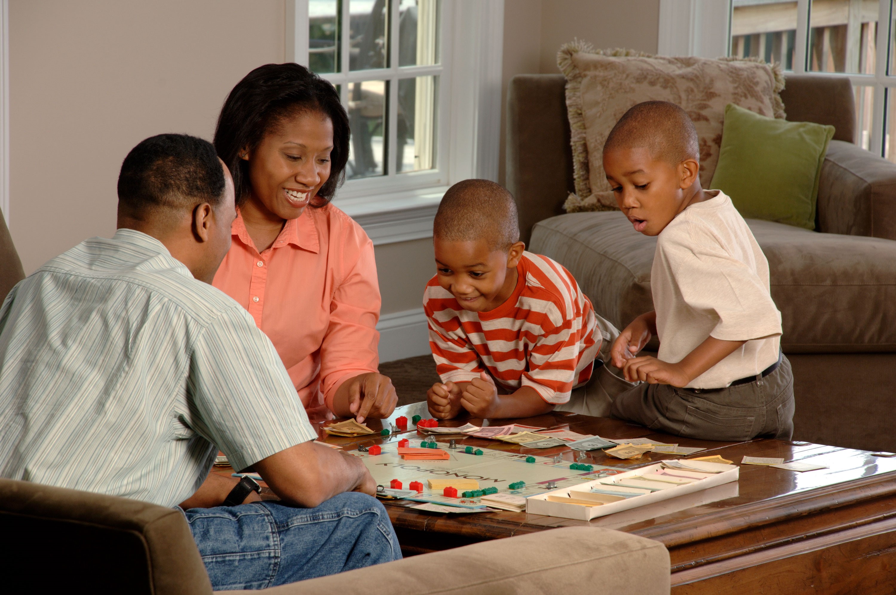 Two adults and two children playing a board game.