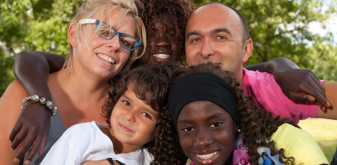 A family with their arms around each other smiling.