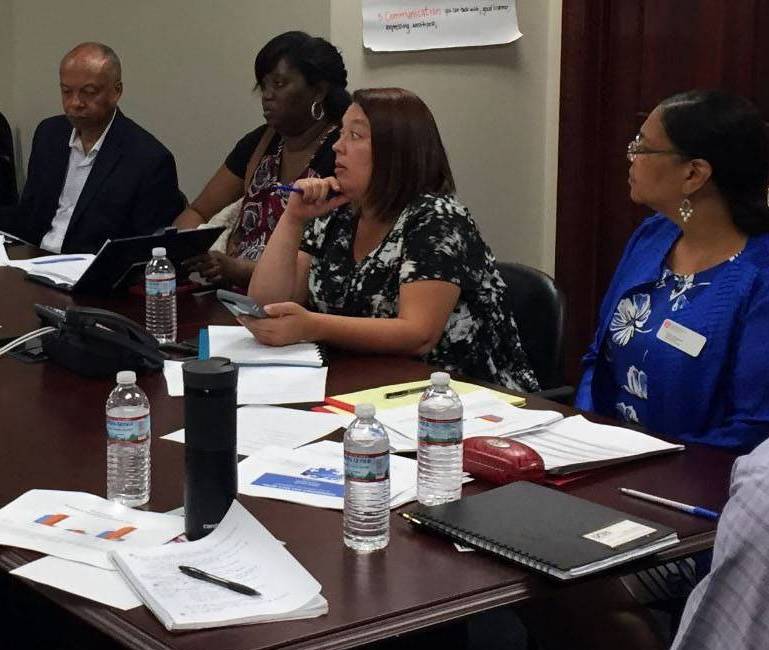 Macon community leaders talking at a table.